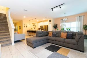 sala de estar con sofá y cocina en Magnificent 5Bd w/ Pool Close to Disney @Storey Lake 4800, en Kissimmee