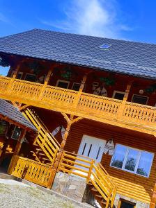 a large wooden house with wooden stairs on it at Breb Casa Luca in Breb