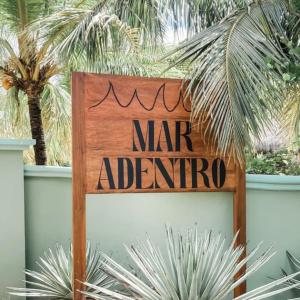 Un signe qui dit mar adiantino à côté de certaines plantes dans l'établissement Mar Adentro Sanctuary, à Tola