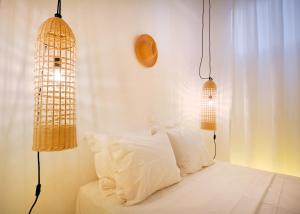 a bedroom with two hanging lights and a bed at Sea Breeze Mykonos in Mykonos +40 photos