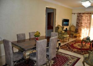 ein Esszimmer mit einem Holztisch und Stühlen in der Unterkunft Mercy gardenia apartment-heliopolis new Cairo 518 Al Yasmin Zone,6th floor in Kairo