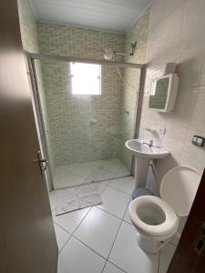a bathroom with a shower and a toilet and a sink at Hotel Modelo in Poços de Caldas