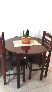 a wooden table with two chairs and a plant on it at Pousada Montanha da Pedra Grande in Atibaia