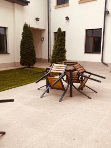 two picnic tables and chairs in front of a building at Han Dunarea in Călăraşi