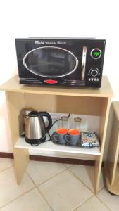 a microwave oven on a shelf with pots and pans at Pousada Montanha da Pedra Grande in Atibaia