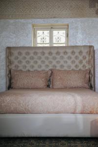 ein großes Bett mit rosa Kissen in einem Zimmer in der Unterkunft Riad Amelia : Lalla Nora Room in Tétouan