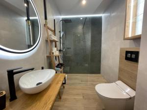 W łazience znajduje się biała umywalka i prysznic. w obiekcie KOBIELA APARTMENTS Dębowe Tarasy w mieście Katowice