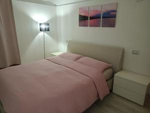 una camera da letto con un letto con lenzuola rosa e una lampada di Casa vacanza Pratola a Pratola Peligna