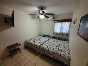 1 dormitorio con 1 cama y ventilador de techo en Central Departamento, en Mazatlán