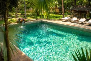 a person bending over in a swimming pool at Eleven Pearl Boutique Hotel & Spa in Diani Beach