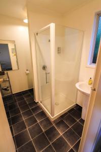 a bathroom with a shower and a sink at Sundowner Motel in Greymouth
