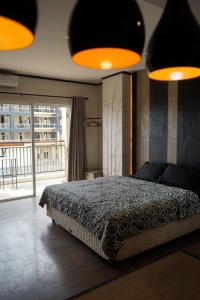 a bedroom with a bed and a large window at Student park apartment in Seturan