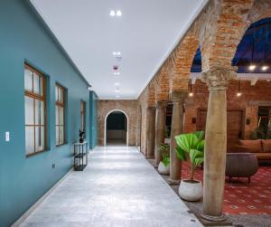 um corredor com paredes azuis e um corredor com colunas em Wanderlot - Hotel Plaza Central em Riobamba