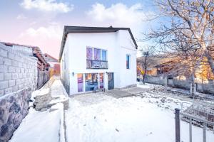 ein weißes Haus mit Schnee auf dem Boden in der Unterkunft sweet dreams bakuriani in Bakuriani