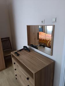 a mirror above a wooden dresser in a room at daily rental apartment 5 minutes to the airport in Pazar