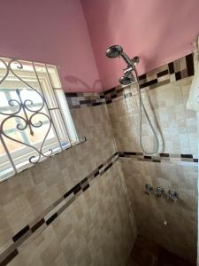 y baño con ducha y ventana. en Seaview Villa en St Mary