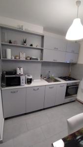 a kitchen with white cabinets and a sink at Ana Apartament in Râmnicu Vâlcea +32 photos