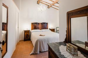 a bedroom with a white bed and a mirror at Locanda Mescoglia in Corciano