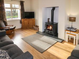 ein Wohnzimmer mit Kamin und Couch in der Unterkunft Rosies Cottage in Bushmills