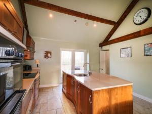 eine Küche mit Spüle und einer Uhr an der Wand in der Unterkunft Rosies Cottage in Bushmills + 14 Fotos