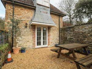 a picnic table in front of a brick building at Aldrich Cottage in Kilmersdon