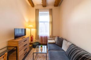 a living room with a couch and a tv at S42 Hotel Prague in Prague