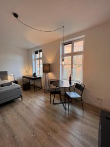 un soggiorno con tavolo, sedie e letto di Apartmenthaus Buxtehude St -Petri-Platz Studiowohnung 3 a Buxtehude