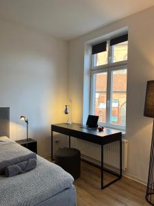 ein Schlafzimmer mit einem Schreibtisch und einem Laptop darauf in der Unterkunft Apartmenthaus Buxtehude St -Petri-Platz Studiowohnung 3 in Buxtehude