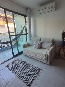 a living room with a couch and a large window at Apartamento - Centro Porto de Galinhas in Escada