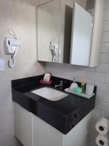 a bathroom with a sink and a mirror at Apartamento - Centro Porto de Galinhas in Escada