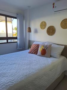 a bedroom with a bed with two pillows and a window at Apartamento - Centro Porto de Galinhas in Escada