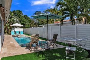 um pátio com uma mesa, cadeiras e um guarda-sol em Sandcastles & Sunshine at Towering Palms of Wilton Manors residence em Fort Lauderdale