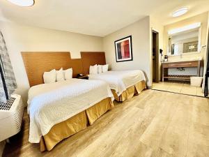 Cette chambre comprend deux lits et une salle de bains. dans l'établissement Days Inn & Suites by Wyndham Arlington Near Six Flags, à Arlington