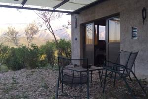 dos sillas y una mesa frente a una casa en bellos atardeceres en Villa Las Rosas