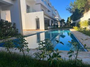 a swimming pool in front of a building at Luxurious Apt with Pool&Sea View in Pont Blondin