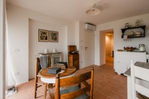 a dining room with a table and a kitchen at Locanda Mescoglia in Corciano