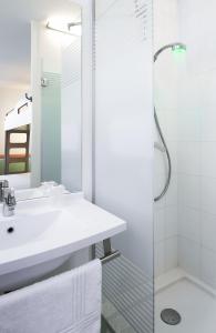 uma casa de banho branca com um lavatório e um chuveiro em ibis budget Antwerpen Centraal Station em Antuérpia