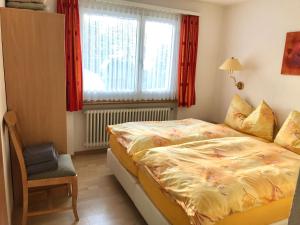 - une chambre avec un lit, une fenêtre et une chaise dans l'établissement Chalet Alm, à Zermatt