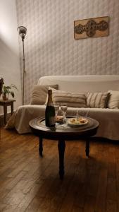 una sala de estar con una mesa con una botella y vasos en La Grive d'Arce en Merrey-sur-Arce