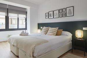 1 Schlafzimmer mit einem großen weißen Bett und 2 Fenstern in der Unterkunft Enjoy - Basque Stay in Añorga-Lugariz