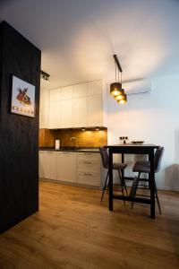 a kitchen and dining room with a table and chairs at Sunny Apartment Lwowska 10 in Kraków