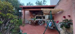 une terrasse avec une table et des chaises dans une maison dans l'établissement Sa Domu Frisca, à Domusnovas