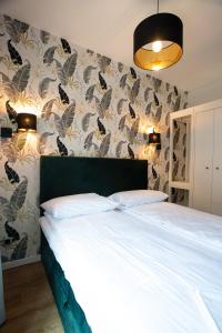 ein Schlafzimmer mit einem Bett und einer Wand mit Schmetterlingen in der Unterkunft Krakow Centrum Sunny Apartment Lwowska 10 in Krakau