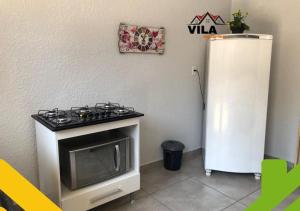 y cocina con fogones y nevera. en APARTAMENTO MARAVILHOSO 4 en Foz de Iguazú