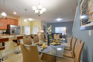 una sala da pranzo e una cucina con tavolo e sedie di Five Bedrooms TownHome with Pool 4849 a Kissimmee