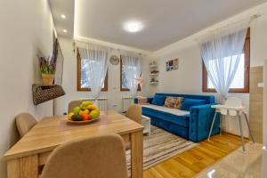 a living room with a blue couch and a table at Dobro Mesto in Zlatibor