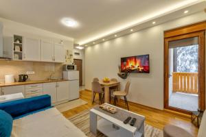 a living room with a blue couch and a kitchen at Dobro Mesto in Zlatibor