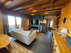 ein Wohnzimmer mit einem Sofa und einem Tisch in der Unterkunft Haut de Chalet L'entasse n°9 in Valberg