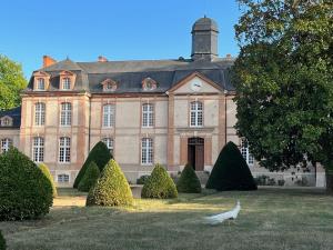 un edificio con un pájaro parado frente a él en 24H LE MANS Château de Lauresse chambres d'hôtes Luxe en Le Mans