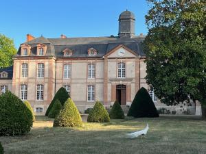 un edificio con un pájaro parado frente a él en 24H LE MANS Château de Lauresse chambres d'hôtes Luxe, en Le Mans